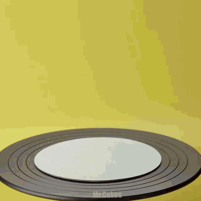 a person is cutting a piece of cake on a cake stand that says mrcakes on the bottom