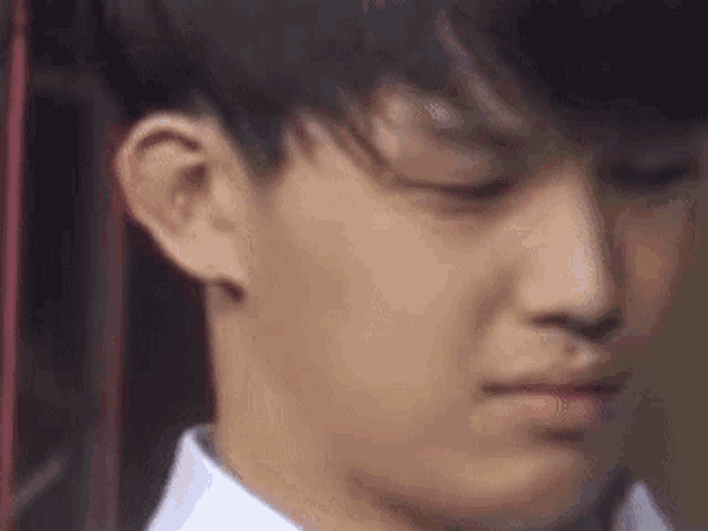 a close up of a young man 's face with his eyes closed and his mouth open .