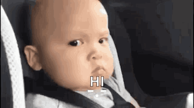 a baby is sitting in a car seat with a seat belt on .