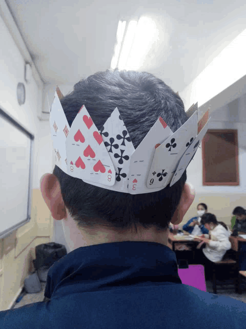 a person wearing a crown made out of playing cards with the ace of hearts on it