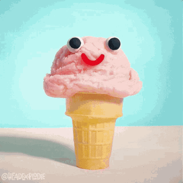 a strawberry ice cream cone with a monster face on top of it