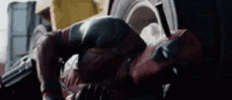 a close up of a man in a deadpool costume laying on his back .