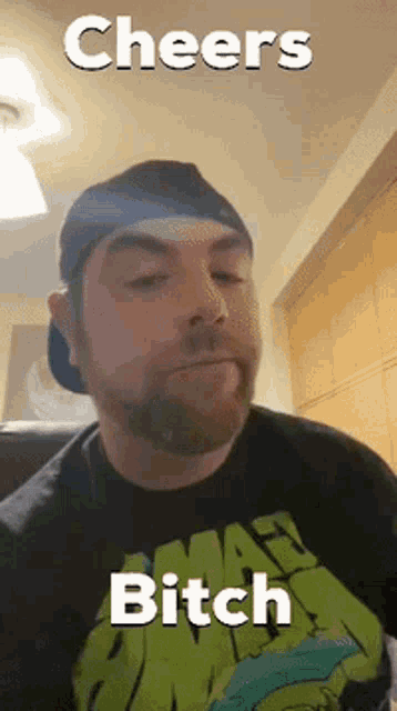 a man with a beard is wearing a black shirt that says cheers bitch