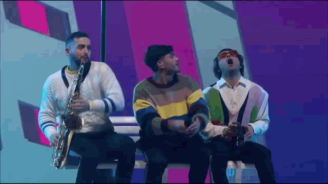 three men are sitting on a bench playing instruments .