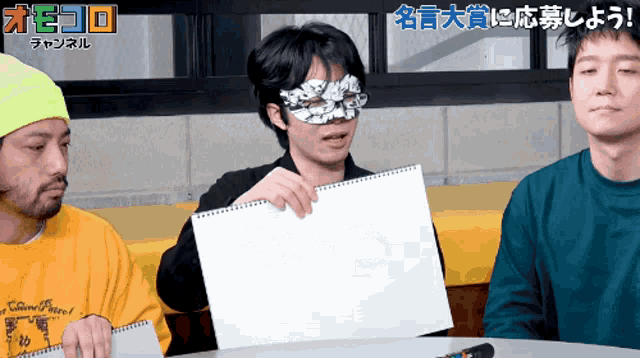 a man with a mask on his face holds a piece of paper in front of a sign that says channel