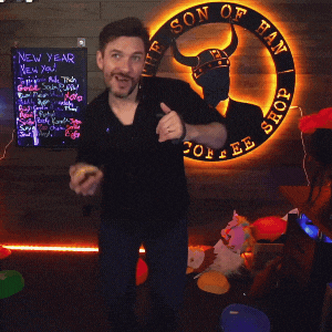 a man giving a thumbs up in front of a sign that says on of fan shop