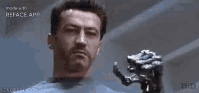 a man is holding a robotic hand in front of his face .