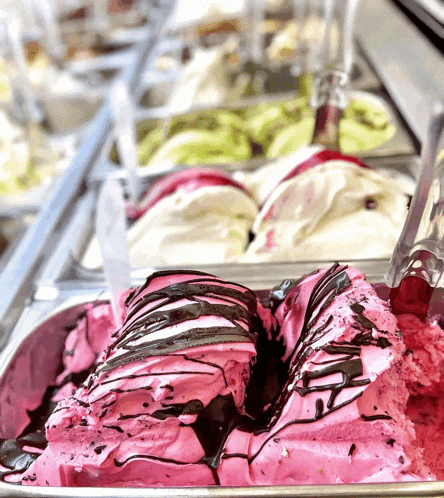 a container of pink ice cream with chocolate drizzle
