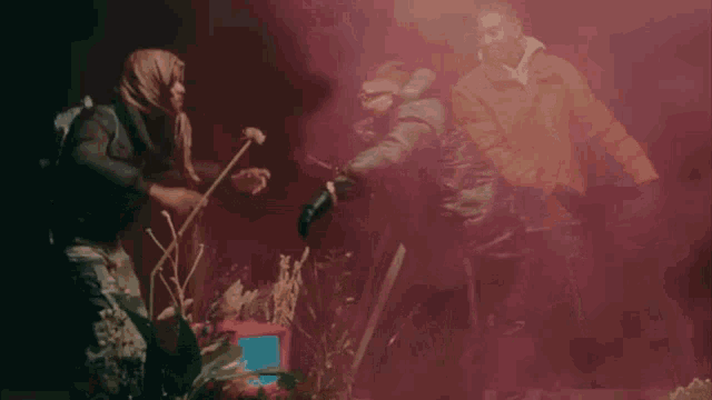 a group of people are standing in a dark room with smoke coming out of it