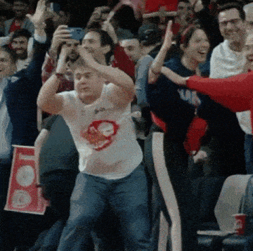 a man wearing a shirt that says ' ain ' on it is dancing in a crowd