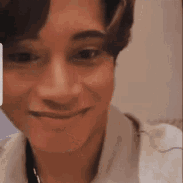 a close up of a person 's face with a white shirt on .
