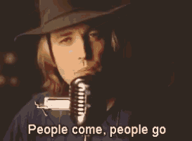 a man in a cowboy hat singing into a microphone with the words people come people go below him