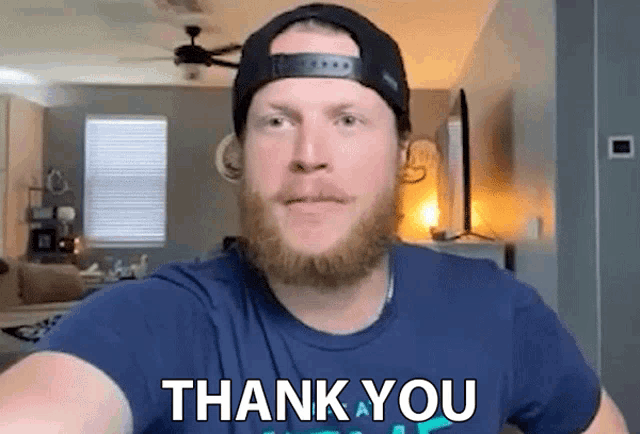 a man with a beard is wearing a hat and a shirt that says thank you