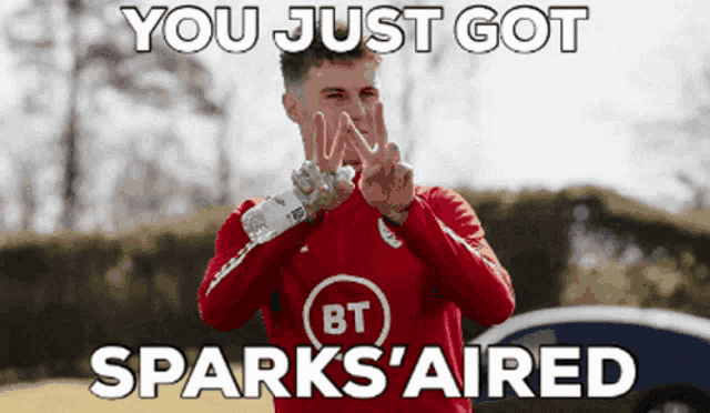 a man in a red bt shirt is holding a water bottle
