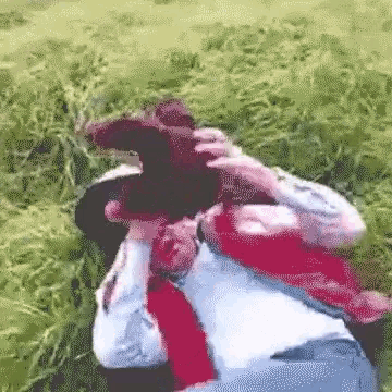 a man in a cowboy hat takes a picture of a woman in a field
