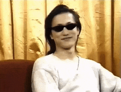 a man wearing sunglasses is sitting on a couch .