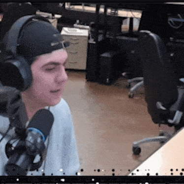 a man wearing headphones is talking into a microphone in an office