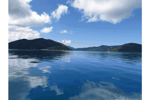 a lake with mountains in the background and a blue sky