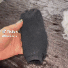 a person is holding a black sock in their hand with tiktok written on it .