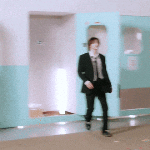 a blurry picture of a man in a suit walking down a hallway