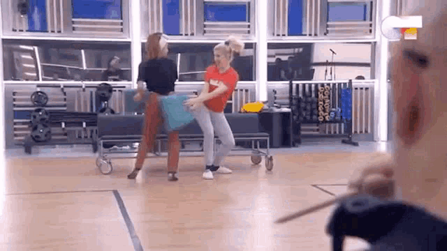 two women are dancing together on a dance floor .