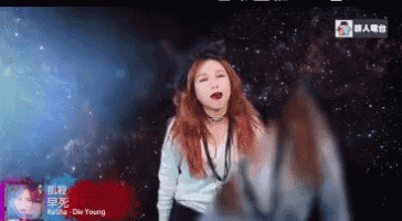 a woman with red hair is standing in front of a starry sky and a sign that says die young