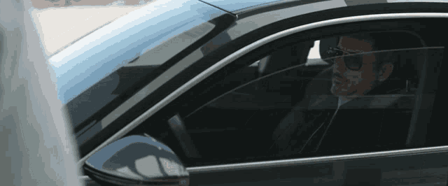a man in sunglasses is sitting in a car