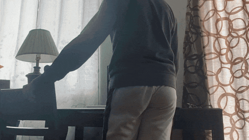 a person standing in front of a table with a lamp