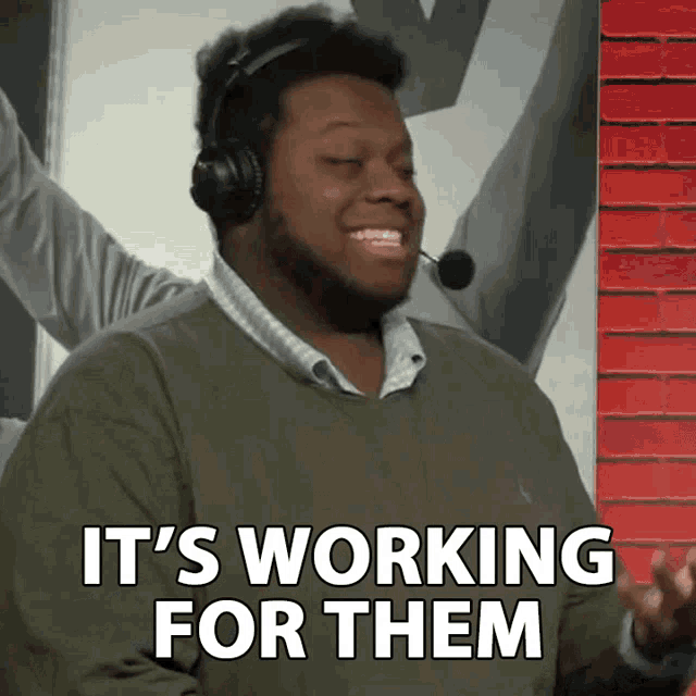 a man wearing headphones and a microphone says it 's working for them