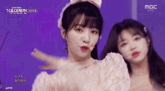 two girls are performing on a stage with the words mbc live on the bottom right