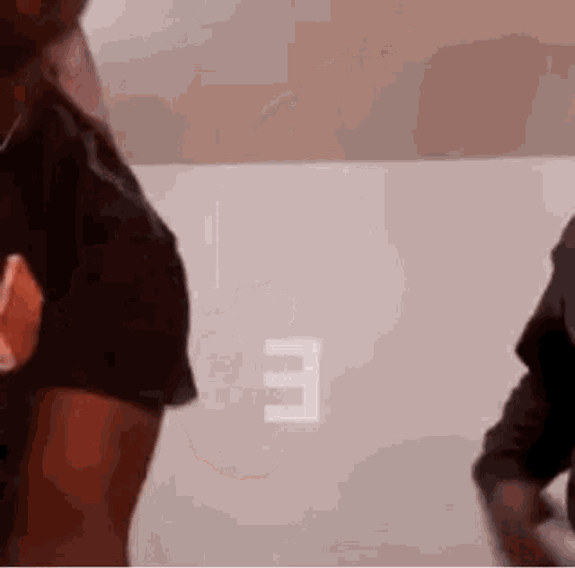 a man in a black shirt is standing next to another man in a white shirt .