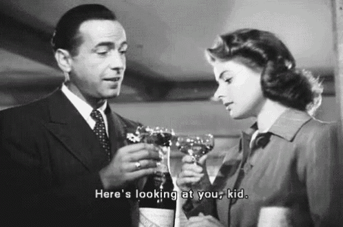 a man and a woman are toasting with wine glasses . the man is holding a bottle of wine .