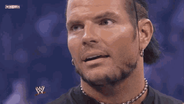 a close up of a man 's face with a wwe logo on the bottom right