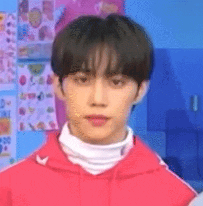 a close up of a person wearing a red jacket and a white turtleneck .