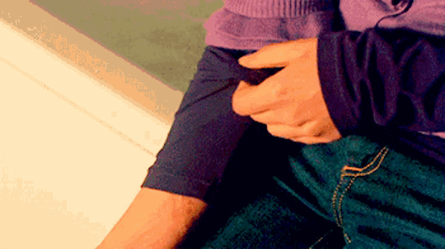 a person holding another person 's arm with their hands