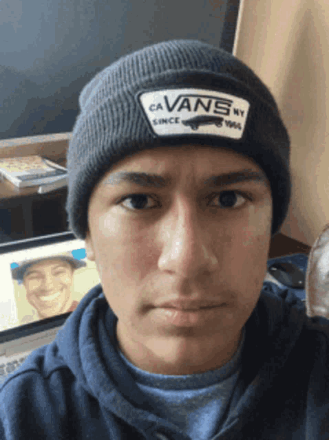 a young man wearing a beanie that says ca vans on it