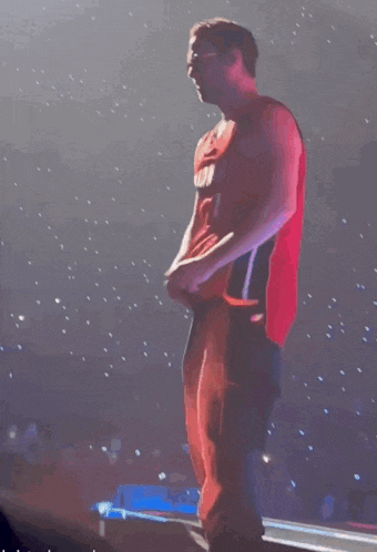 a man in a red jersey with the number 1 on it stands on a stage
