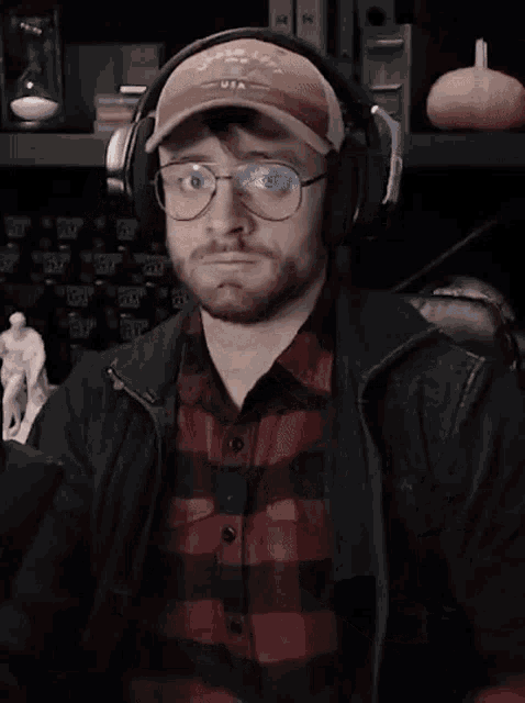 a man wearing glasses and headphones is making a face .