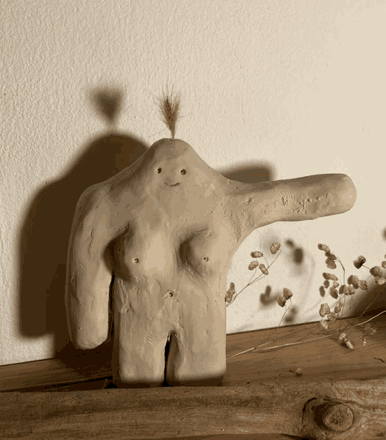 a statue of a woman 's torso with a shadow on the wall