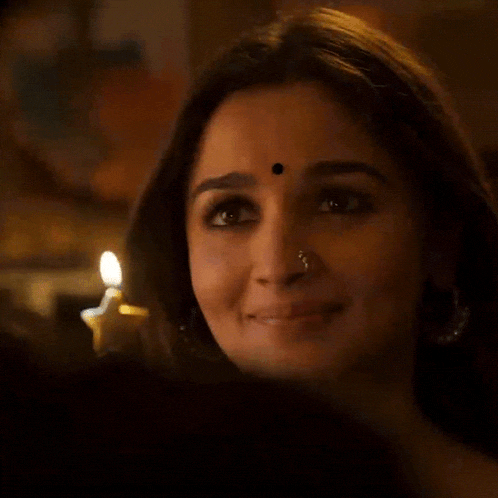 a close up of a woman 's face with a star shaped candle in the background