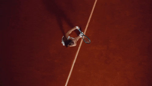 an aerial view of a tennis player hitting a tennis ball