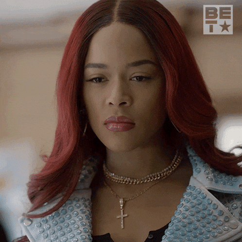 a woman with red hair and a necklace with a cross on it