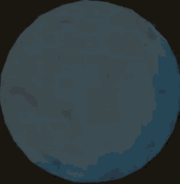 a blue sphere is sitting on top of a dark surface .