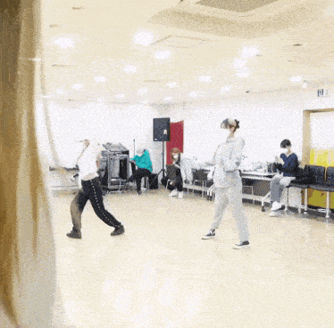 a group of people are dancing in a room with a sign that says exit on it
