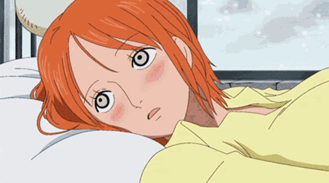 a woman with orange hair is laying on a bed with a yellow blanket