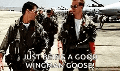 two men in military uniforms are standing next to each other on an airport tarmac .
