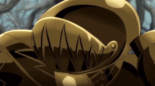 a close up of a gold object with a tbs logo on the bottom