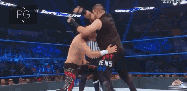 two men are wrestling on a wrestling mat in a ring .