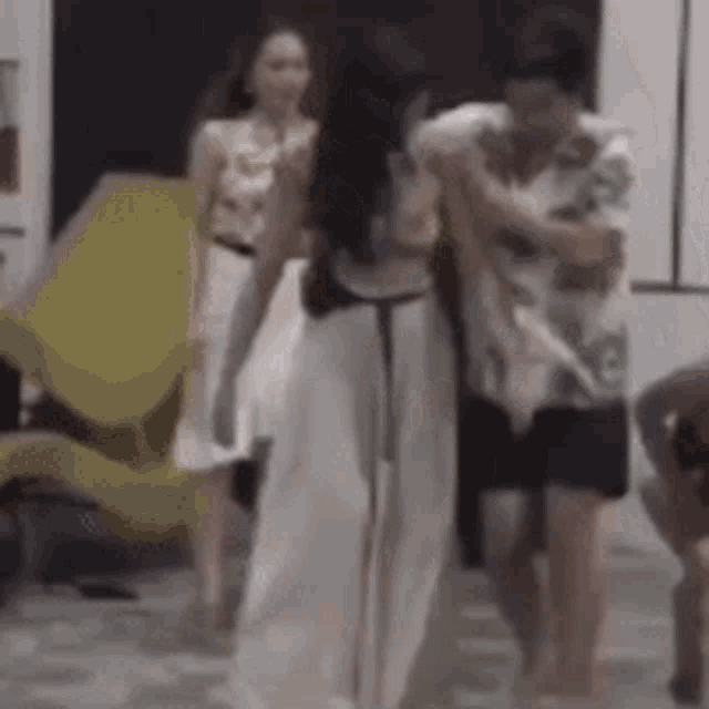 a group of people are standing around a woman in a room .
