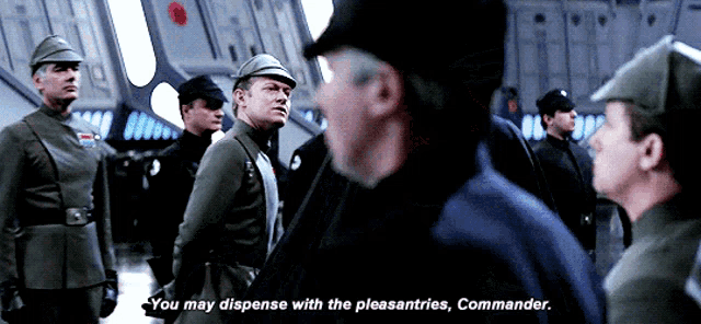 a group of men are standing in a room and one man says " you may dispense with the pleasantries "